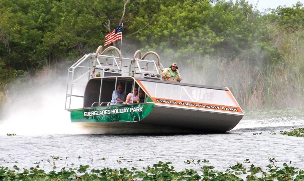 Everglades boat trip Tourists on an airboat ride with the American flag waving